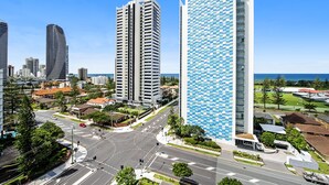 A modern urban area with high-rise buildings, a roundabout, and a view of the sea.