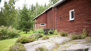 A rustic wooden building with a small window and a bench in front.