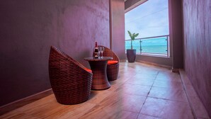 A modern interior with wicker furniture, a small table, and a potted plant. - Aloha Hotel (Pontian)
