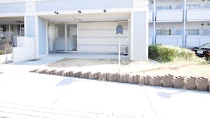 A modern building with a flat roof, a covered entrance, and a parking meter. - Lica's Room (Kyoto)