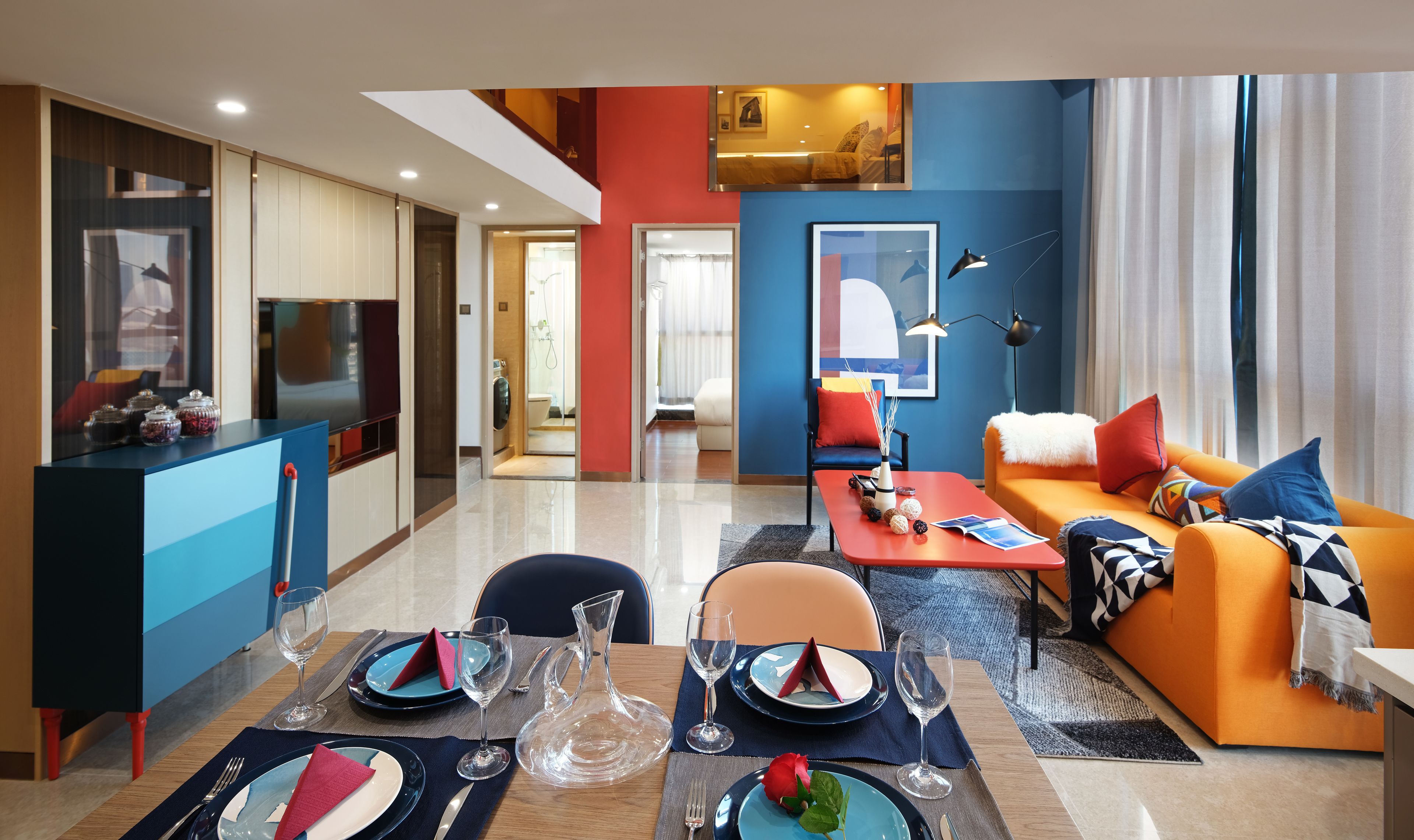 A modern living room with a dining area, featuring a sofa, a coffee table, and a TV.