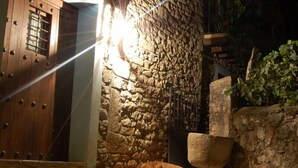 A stone wall with a sleeping dog and a wooden door. - El Capricho de Nieves (Laspuna)