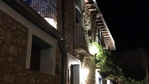 A stone building with a stone staircase leading to a balcony. There is a door on the ground floor and a window on the upper floor. - El Capricho de Nieves (Laspuna)