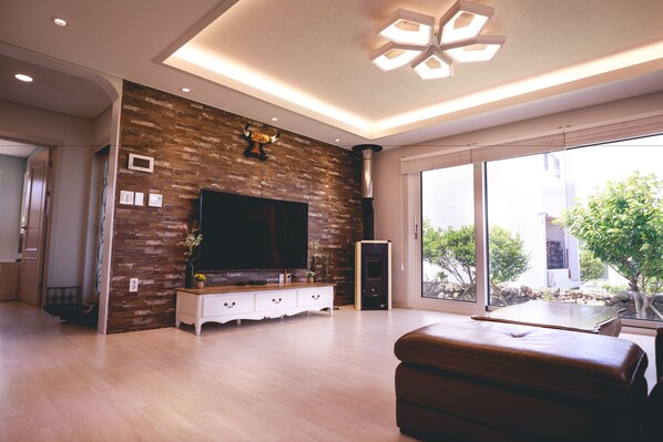 Hus – premium, 3 soverom, badstue, delvis havutsikt | Oppholdsområde | En 65-tommers LED-TV med kabel-kanaler samt TV