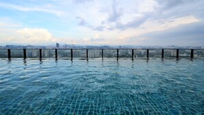 On voit clairement une piscine, avec une vue sur la ville en arrière-plan.