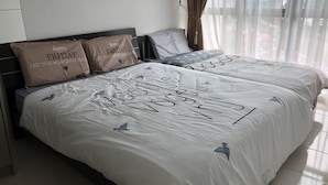 Ein Hotelzimmer mit zwei Betten, jeweils mit weißer Bettwäsche und personalisierten Kissen.