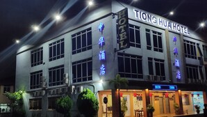 Un hôtel avec une enseigne indiquant « Tiong Hua Hotel » et un numéro de chambre bien visible, le « 23886 ».