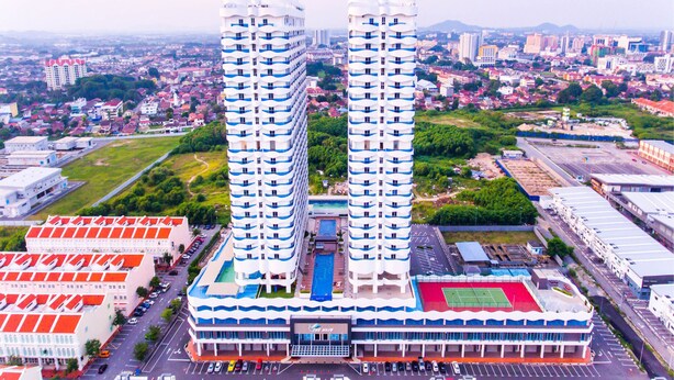 A high-rise hotel with multiple floors, a swimming pool, and a tennis court. - The Wave by ExcluSuites Malacca (Malacca City)
