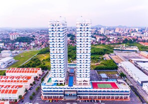 Ein Hochhaus mit mehreren Stockwerken, einem Schwimmbad und einem Tennisplatz.