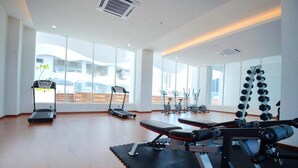 A modern gym with treadmills, elliptical machines, and free weights. - The Wave by ExcluSuites Malacca (Malacca City)