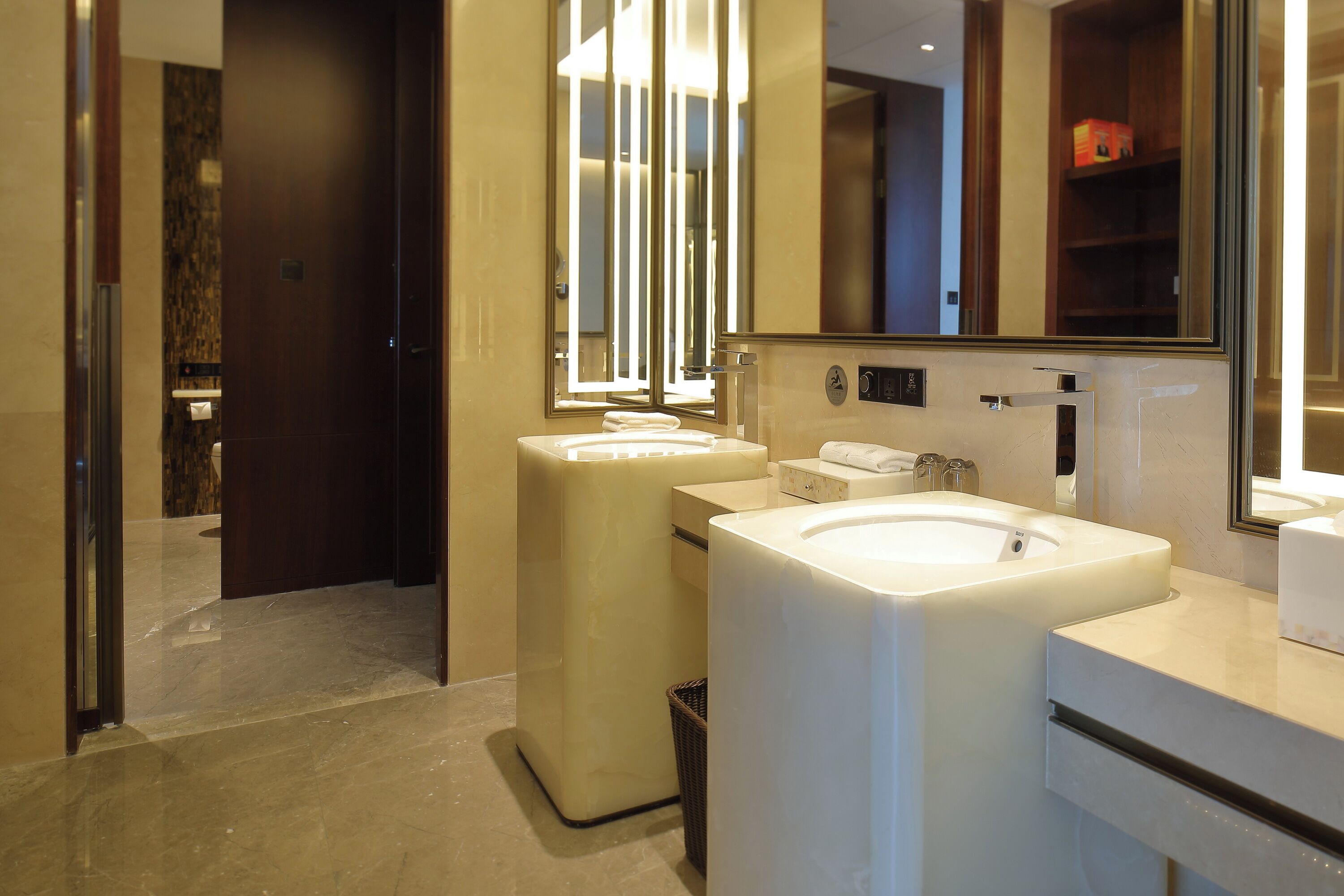 Un baño moderno con un lavamanos grande, un espejo y un inodoro.
