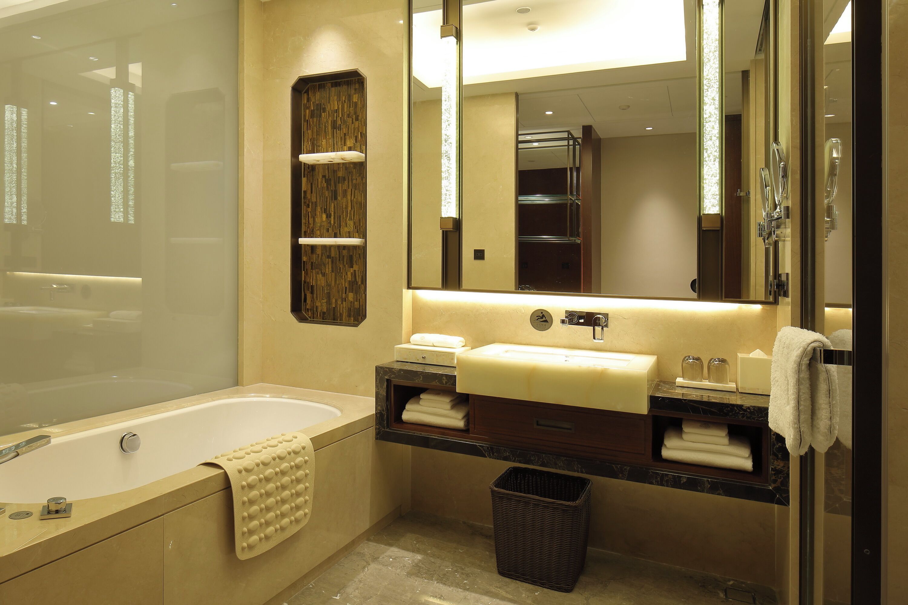 A modern bathroom with a bathtub, a sink, a mirror, and a shower.