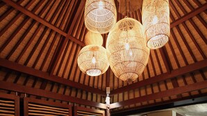 A spacious living area with a high wooden ceiling, a large orange sofa, and a central wooden coffee table. - Villa Palem (Selemadeg)