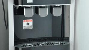 A water dispenser with hot, alkaline, and cold water options, and a warning label. - dr96inn (Kuantan)