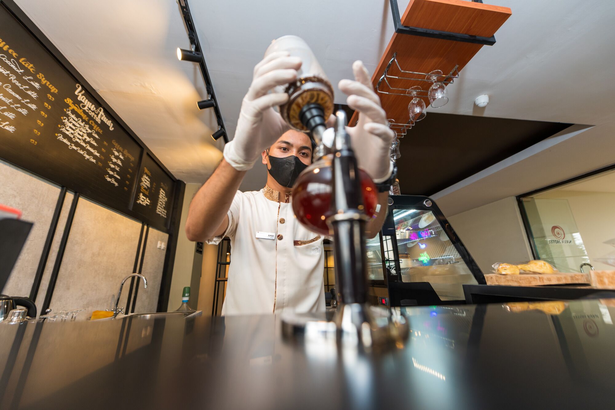 A person operating a coffee machine in a modern kitchen setting.