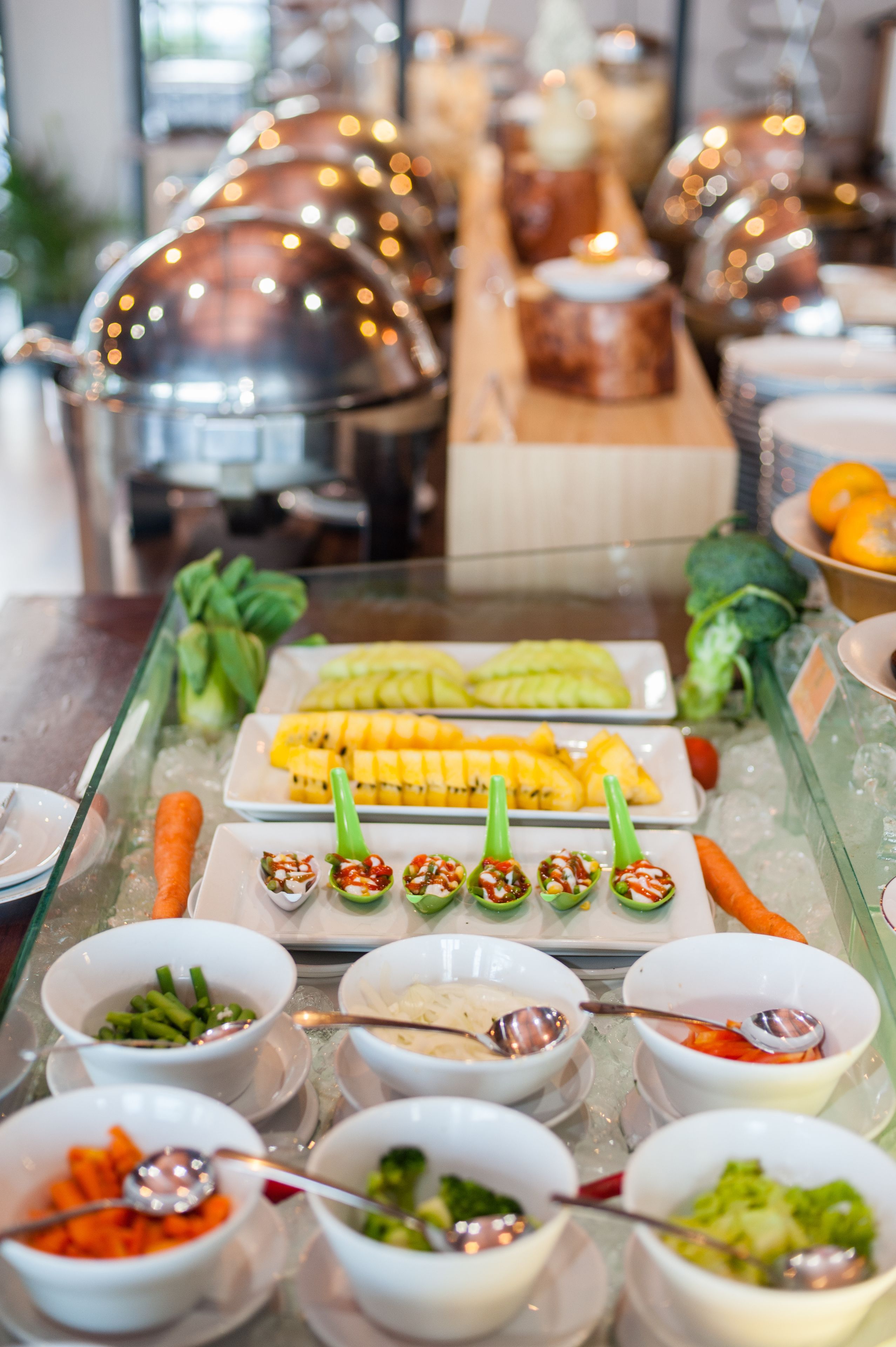 A buffet with various food items and utensils.