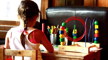 Un niño en una mesa de madera con un juguete.