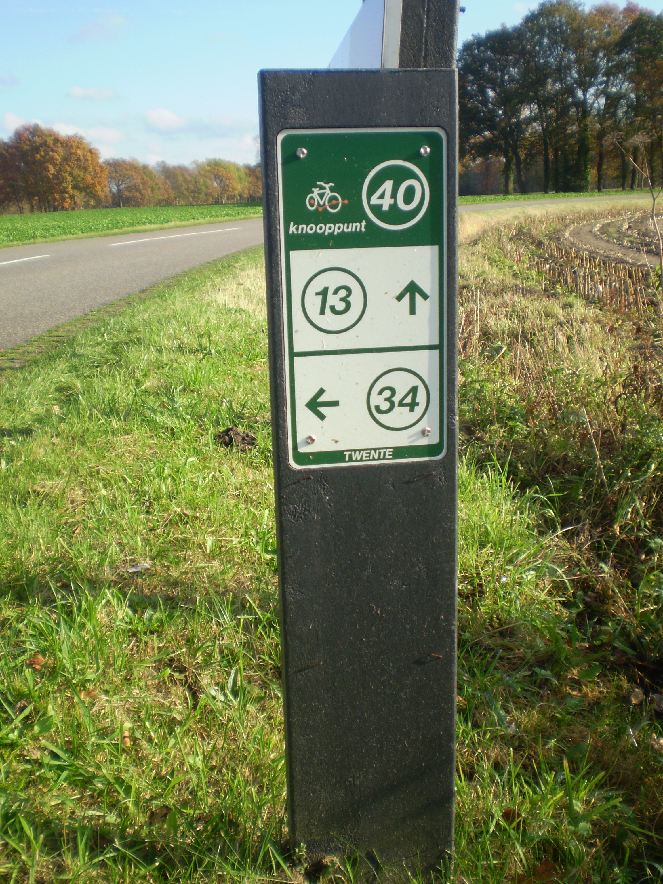 Een richtingsbord met routeaanduidingen en afstanden.