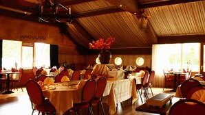 A dining area with tables set for a meal, chairs, and a vase with flowers on one table. - Hotel Restaurant 'T Holt (Diepenheim)