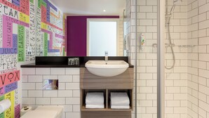A modern bathroom with a white sink, a shower, and a wall covered with colorful sticky notes.