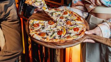 Eine Pizza mit verschiedenen Belägen auf einem Holzboden.