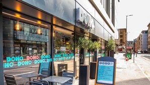 A DOHO cafe with outdoor seating and a menu board. - Ibis Styles Glasgow Central (Glasgow)