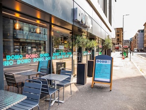 Een DOHO café met terras en een menubord.