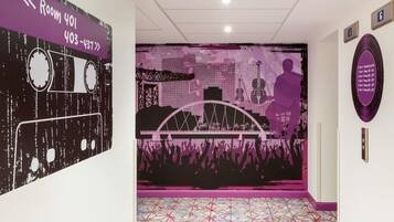A hallway with a purple and black mural, a patterned floor, and a sign indicating Room 401 with a phone number.