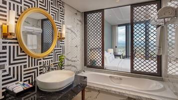 A modern bathroom with a large mirror, a white sink, and a bathtub.