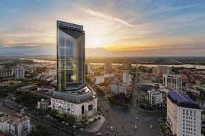 A modern high-rise building with a glass facade and a sign reading "MELIA VINPEARL".
