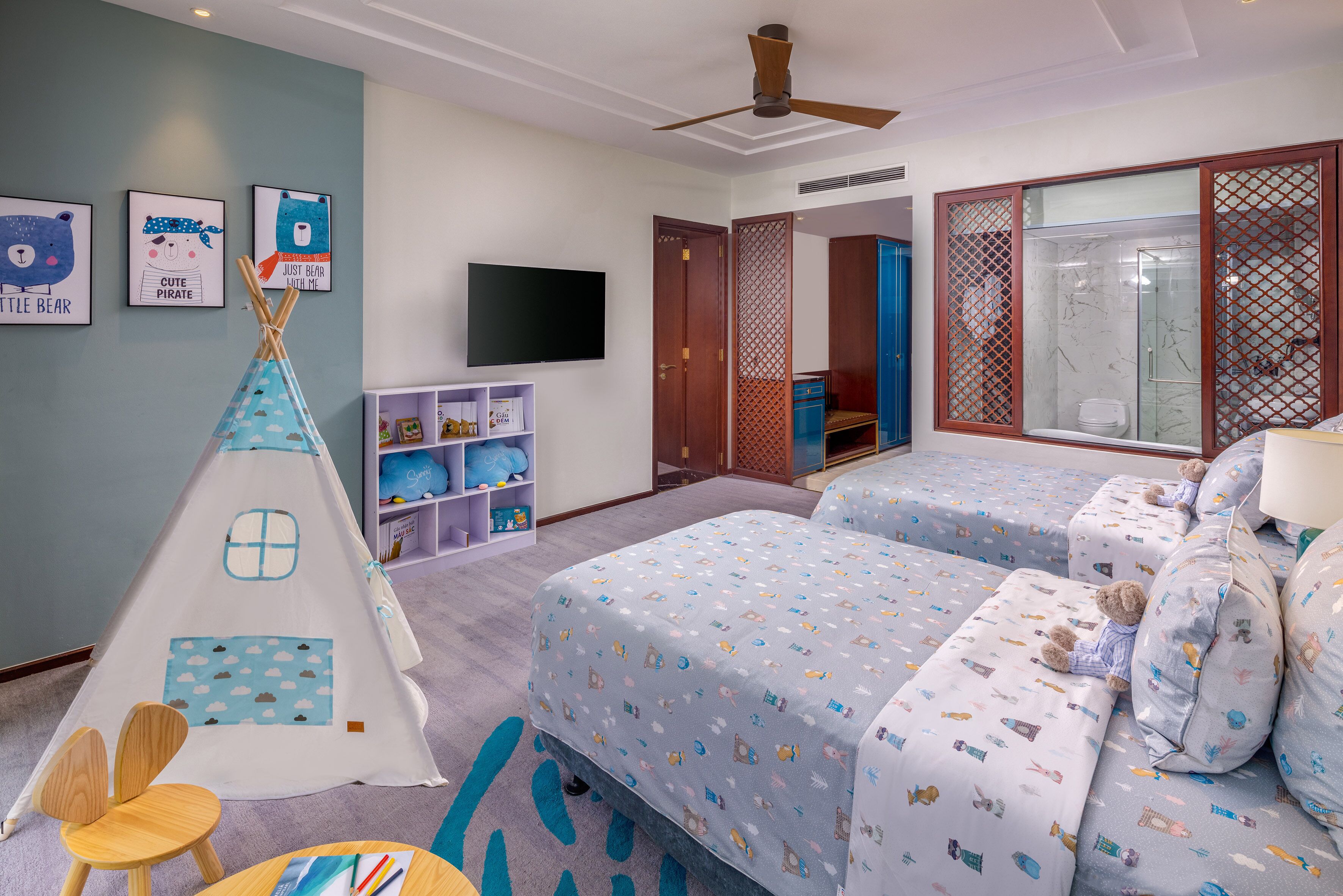 A child-friendly room with two beds, a play area, and a TV.