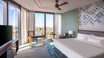 Une chambre d’hôtel moderne, dotée d’un grand lit, d’un bureau et d’une télévision.