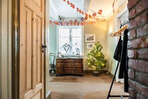 A room with a wooden dresser, a small Christmas tree, and a coat rack. - Reykjavik Treasure (Reykjavik)
