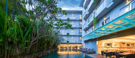 Una piscina al aire libre, sillones reclinables de piscina