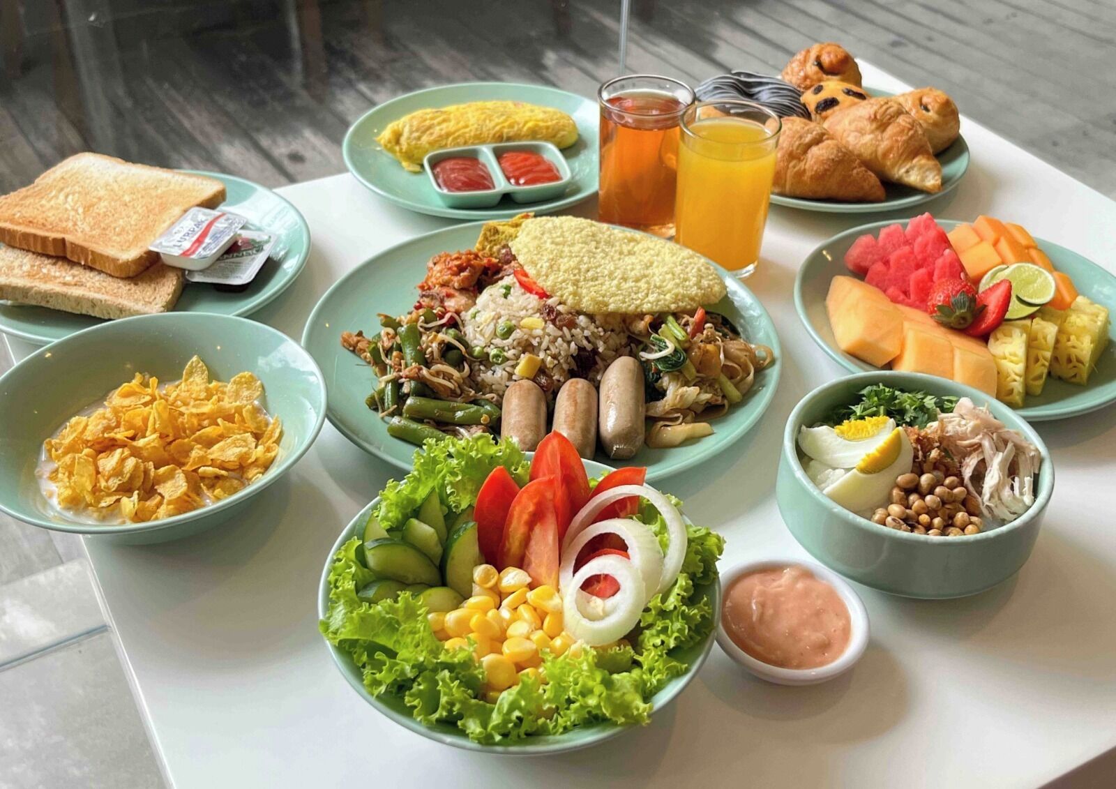Ein reichhaltiges Frühstücksbuffet mit verschiedenen Speisen, darunter Müsli, Reis, Gemüse und Gebäck.