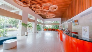 A spacious lobby with a reception desk, seating area, and large windows offering views of the outdoors. - Kuta Galleria Hotel (Kuta)