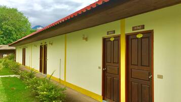 A row of wooden doors with yellow trim and a green wall, each marked with a number.