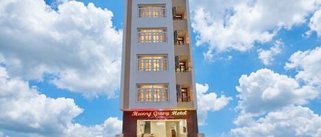 A multi-story hotel with a clear sky and clouds in the background.