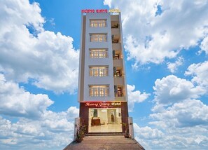 Ein mehrstöckiges Hotel mit blauem Himmel und Wolken im Hintergrund.