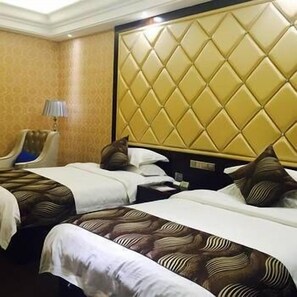 A hotel room with two beds, a headboard with a diamond pattern, a lamp, and a chair.