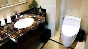 A bathroom with a marble sink, a toilet, and a mirror. - Bojue Hotel (Jiaxing)