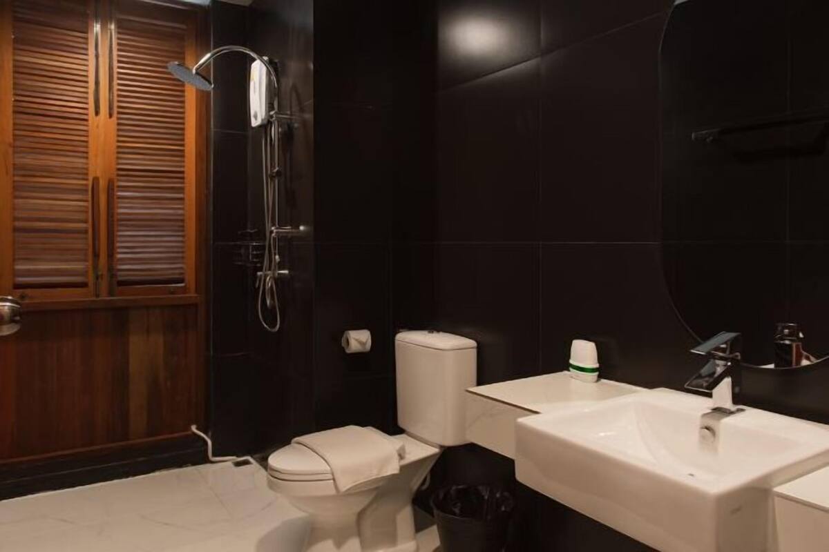 Een badkamer met toilet, wastafel en douche.