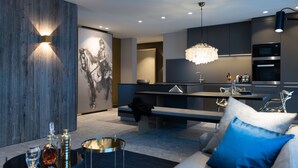Uma sala de estar moderna com sofá, mesa de centro e um espaço de jantar com bancos.