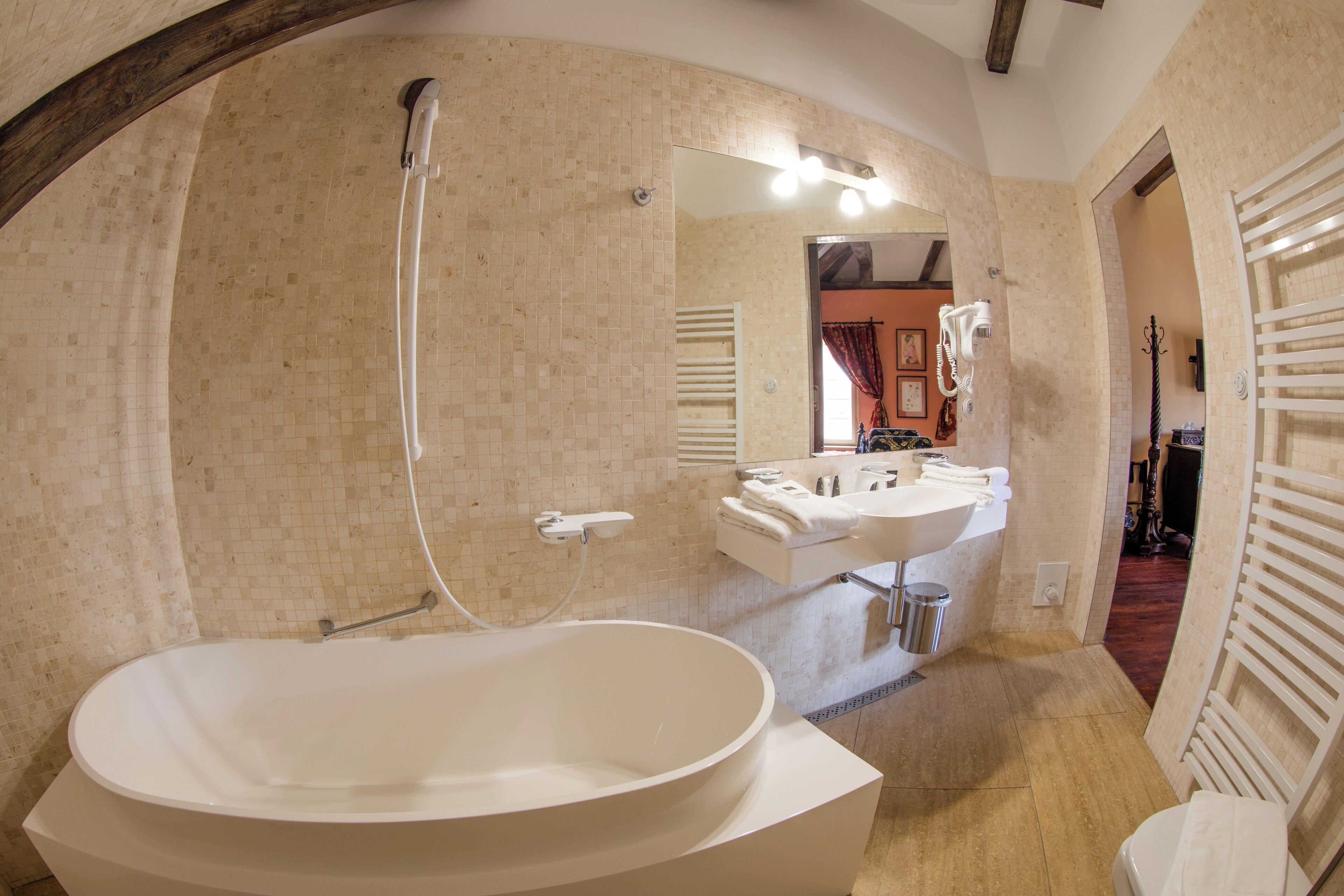 A bathroom with a freestanding bathtub, a sink, a mirror, and a shower.