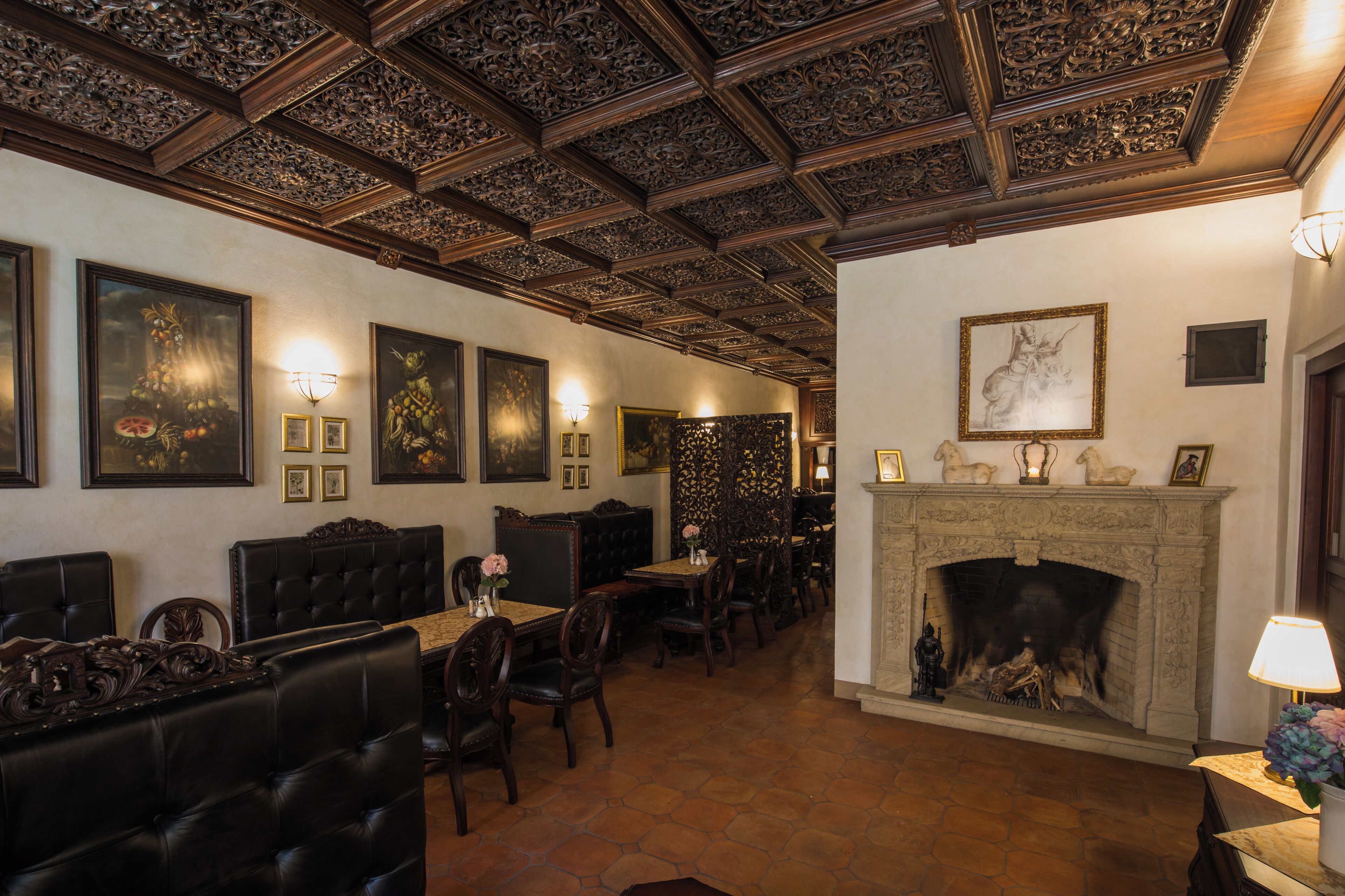 A dining area with wooden furniture, a fireplace, and framed artwork on the walls.