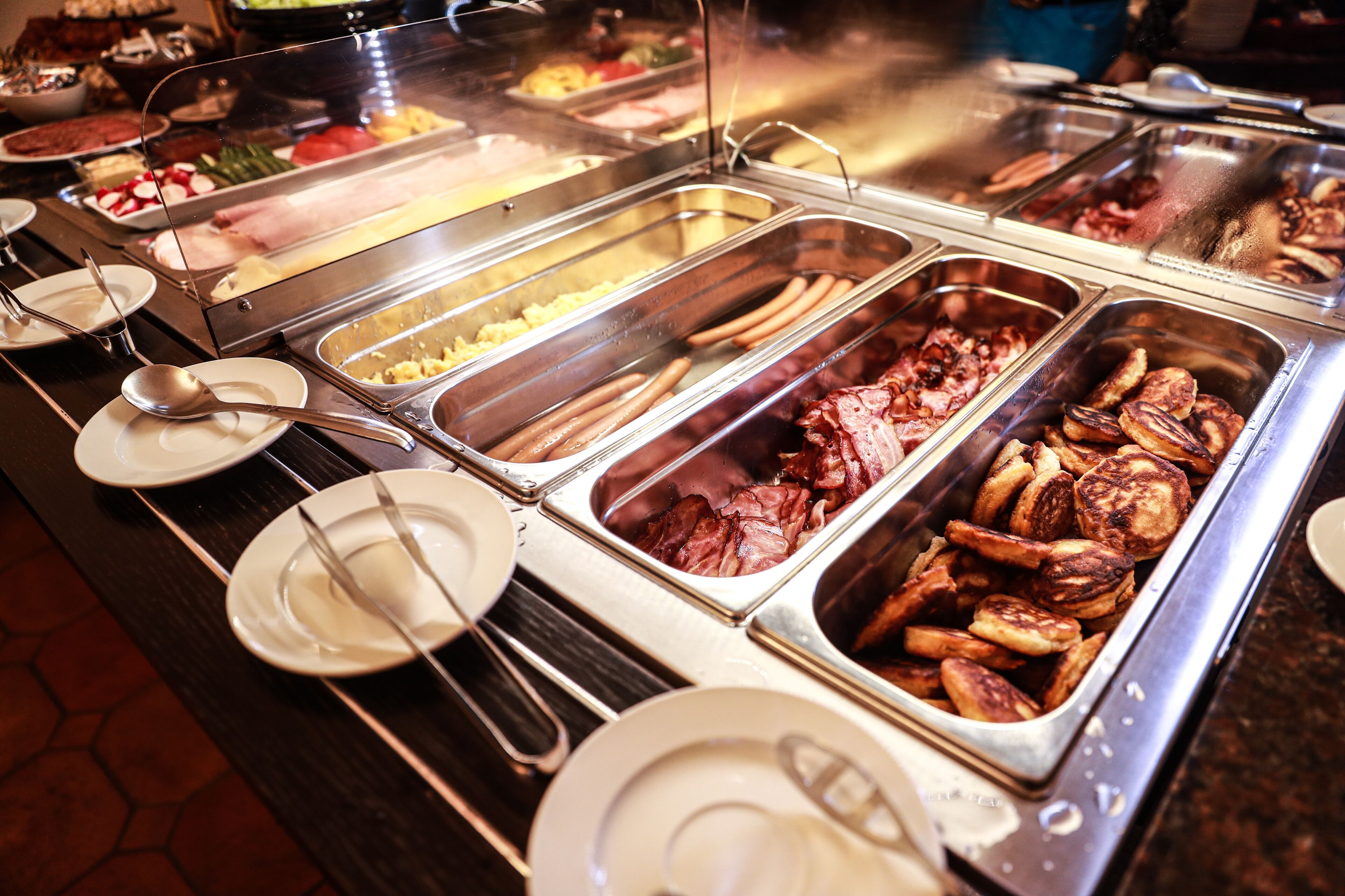 Un bufé con diferentes opciones de comida y utensilios.