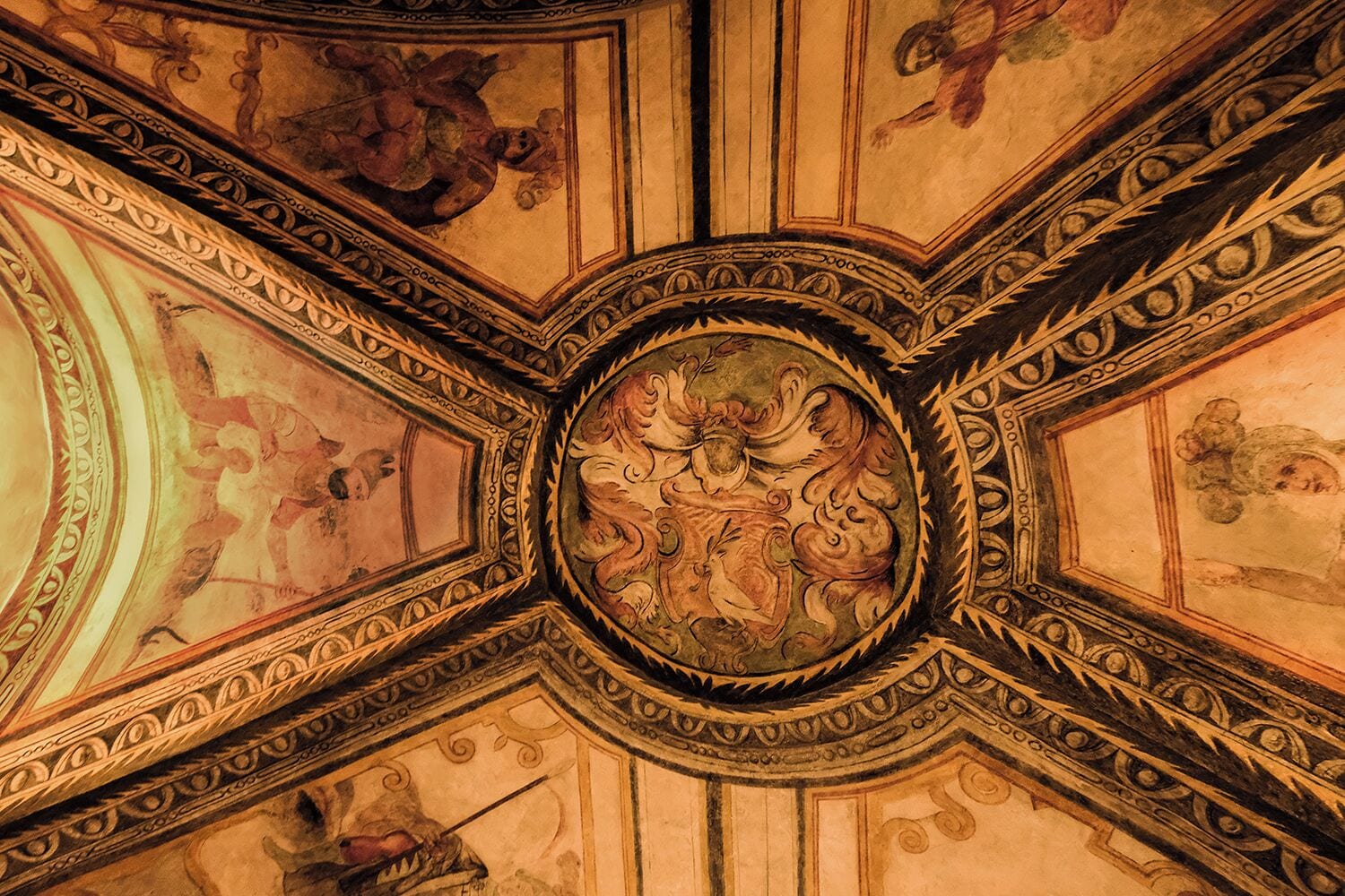 Un plafond richement décoré de motifs complexes et orné d’un motif circulaire central.