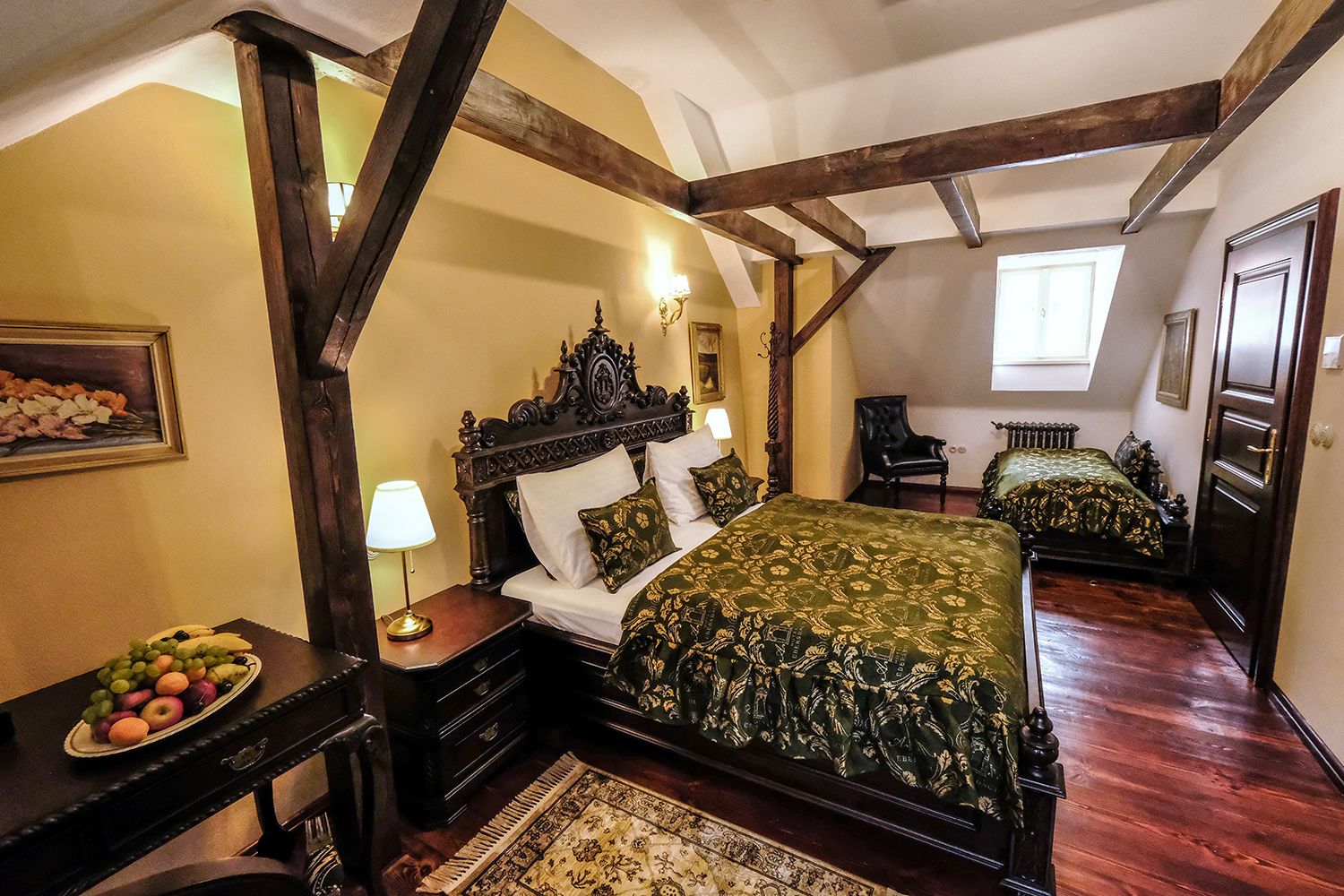 A traditional bedroom with a large bed, a dresser, a nightstand, and a chair.