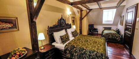 Un dormitorio tradicional con una cama grande, un aparador, una mesita de noche y una silla.