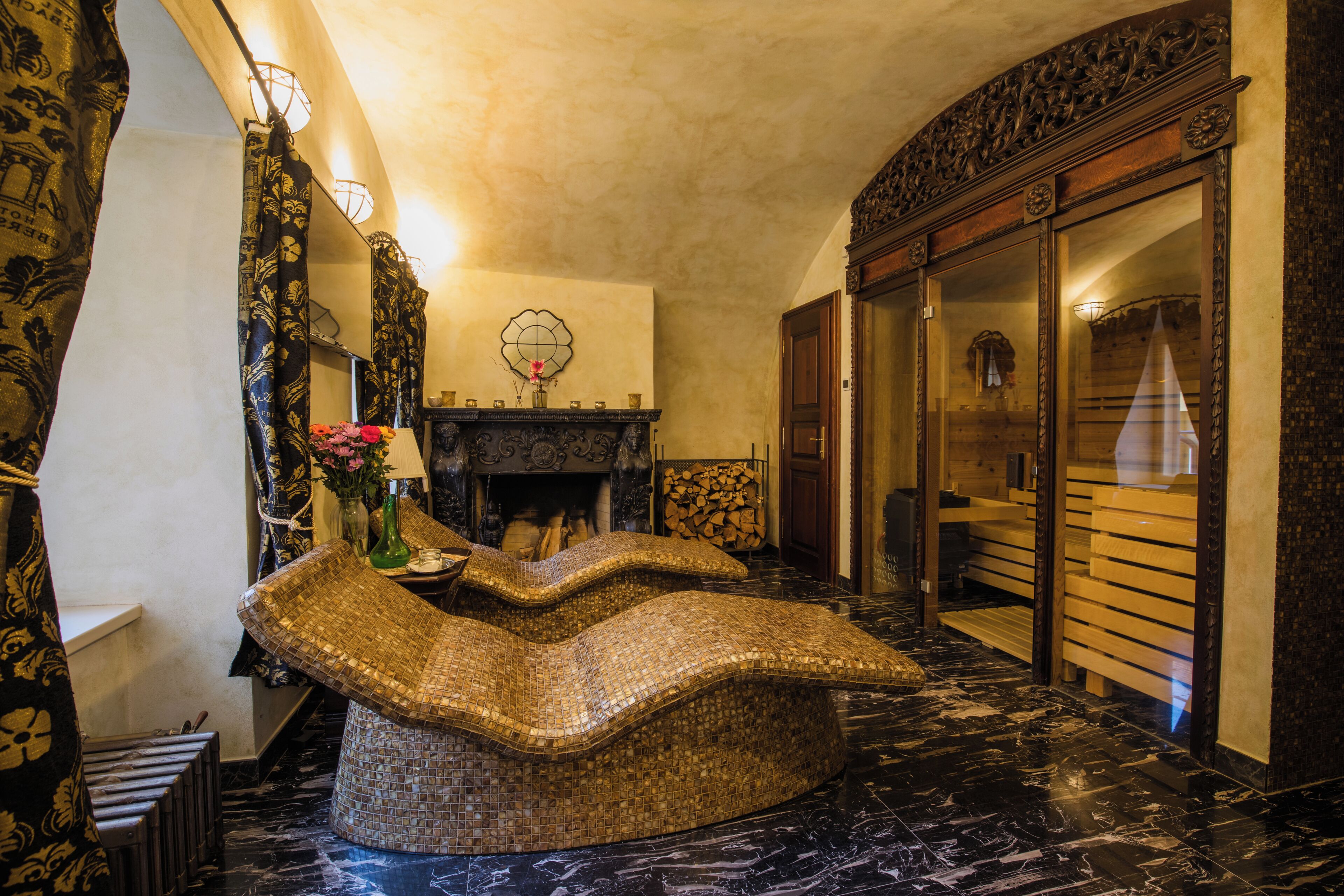Un vestíbulo con un banco de mosaico, chimenea y un espejo grande.